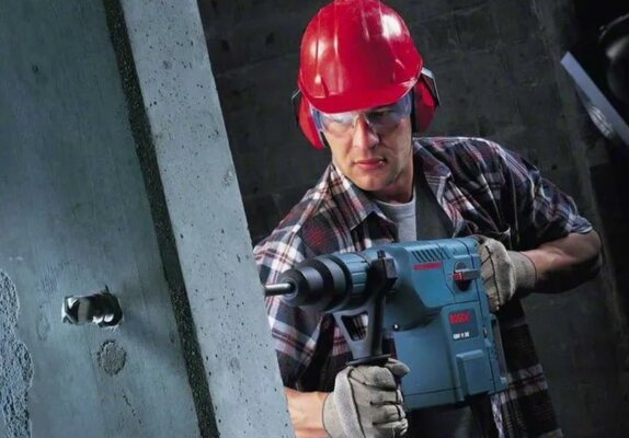 Бурит дырку в стене