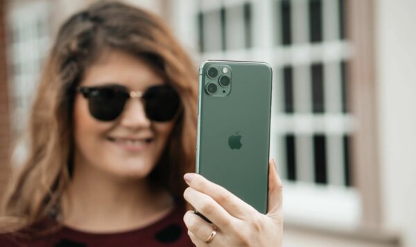 Довольная девушка с iPhone 15